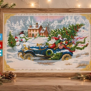 Puede incluir: Obra de arte de punto de cruz en un marco de madera que representa a Papá Noel conduciendo un coche azul vintage por un paisaje nevado. Un árbol de Navidad está en el coche. Muñecos de nieve y una casa están en el fondo.