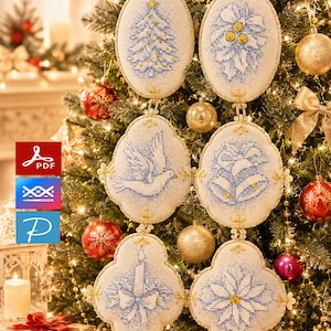 Puede incluir: Seis adornos de tela con forma ovalada y lobulada que presentan bordados en punto de cruz azul de un árbol de Navidad, acebo, una paloma, campanas, una vela y una flor de pascua. Cada pieza tiene un borde dorado y están conectadas.
