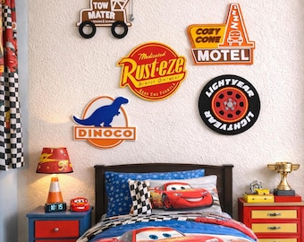 May include: A child's bedroom decorated with Cars movie theme. The room features a bed with a Lightning McQueen comforter, a bedside table with a lamp, and wall decor including signs and a Lightyear wheel.