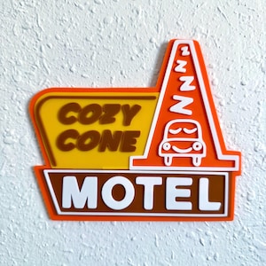 May include: An orange, yellow, and brown Cozy Cone Motel sign. The sign features the words "COZY CONE" and "MOTEL" in white lettering. A cartoon car is sleeping under a series of Z's.