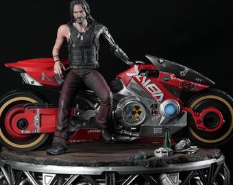 May include: A detailed figurine of a man in a black vest and pants, leaning against a red and silver motorcycle. The motorcycle has the text "YAIBIA" and other graphics. The figure is on a metallic platform with a black background.