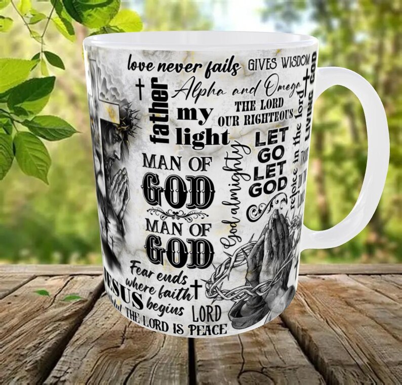May include: White ceramic mug with a marble-like background and religious text and imagery. The mug features phrases like "love never fails" and "Man of God," along with an image of praying hands and a depiction of Jesus.