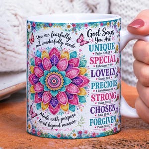 May include: A white ceramic mug featuring a colorful mandala design in shades of pink, yellow, and teal. The mug displays the text 'You are fearfully and wonderfully made' and 'God Says You Are UNIQUE SPECIAL LOVELY PRECIOUS STRONG CHOSEN FORGIVEN'.