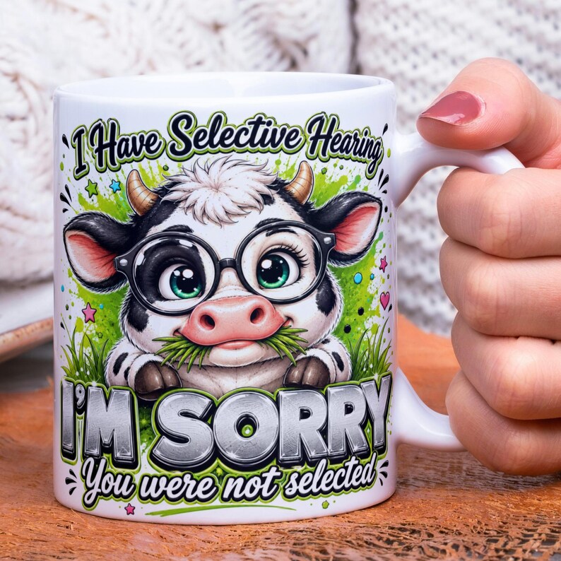 May include: White ceramic mug featuring a cartoon cow wearing glasses and holding grass in its mouth. The mug has the text "I Have Selective Hearing" and "I'M SORRY You were not selected" printed on it. The cow is black and white with green eyes.