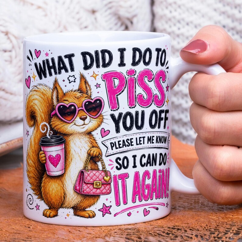 May include: A white ceramic mug featuring a cartoon squirrel wearing pink heart-shaped sunglasses, holding a pink coffee cup and a pink quilted handbag. The text reads: WHAT DID I DO TO PISS YOU OFF PLEASE LET ME KNOW SO I CAN DO IT AGAIN!