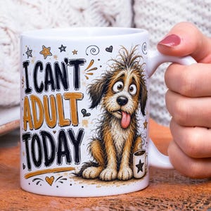 May include: A white ceramic mug featuring a cartoon illustration of a shaggy brown dog with wide eyes and its tongue sticking out. The text "I CAN'T ADULT TODAY" is printed in black and gold lettering alongside small star, heart, and swirl graphics.
