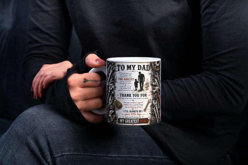 May include: White ceramic mug with the text "TO MY DAD" and a graphic of a father and child walking. The mug also includes the phrases "THE ABILITY", "THANK YOU FOR", "I'LL ALWAYS BE your little boy", and "MY GREATEST HERO".