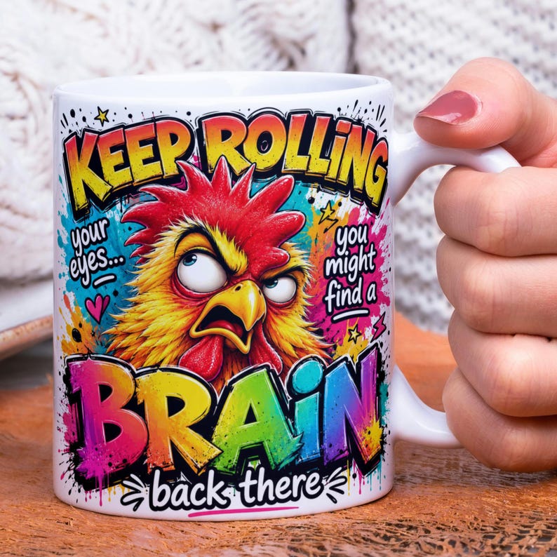 May include: White ceramic mug with a humorous design. The mug features a colorful illustration of an angry rooster and the text "KEEP ROLLING your eyes... you might find a BRAIN back there."