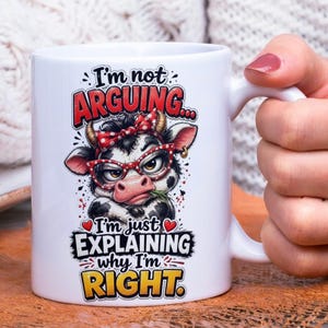 Op de afbeelding: Witte keramische mok met een cartoon koe met een bril en een rode strik. De mok heeft de tekst "I'm not ARGUING... I'm just EXPLAINING why I'm RIGHT."