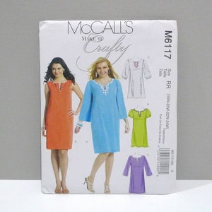 May include: A McCall's sewing pattern, M6117, featuring dress designs. The pattern cover displays illustrations of dresses in orange, blue, green, and purple. The text "Make It Crafty" is visible.