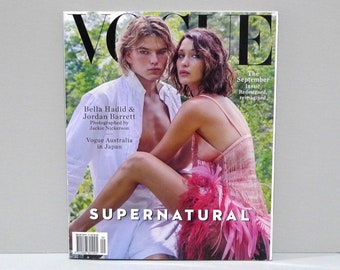 May include: A Vogue magazine cover featuring Bella Hadid and Jordan Barrett. The cover has the word "VOGUE" at the top, with the text "SUPERNATURAL" at the bottom. The September issue is "Redesigned, reimagined."