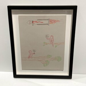 May include: Framed artwork featuring a whimsical illustration. A rocket with a face emits red flames. Two pink birds on a branch hold signs that read "Don't Eat Babies" and "Save Babies". The artwork is framed in a black frame.