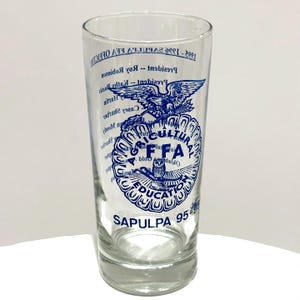 May include: A clear glass tumbler with blue text and graphics. The design includes the letters "FFA", an owl, and the words "Agricultural Education". The text also includes "Sapulpa 95".