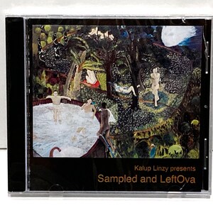 May include: A CD case featuring a colorful, artistic illustration of figures in a lush, green landscape with a body of water. The text "Sampled and LeftOva" is visible on the cover.