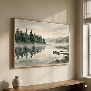 Peut inclure: Impression d'art de paysage à l'aquarelle dans un cadre en bois clair. L'œuvre représente une scène de lac sereine avec une forêt, des montagnes et un petit bateau. Les couleurs sont douces, avec des nuances de vert, de gris et de beige.