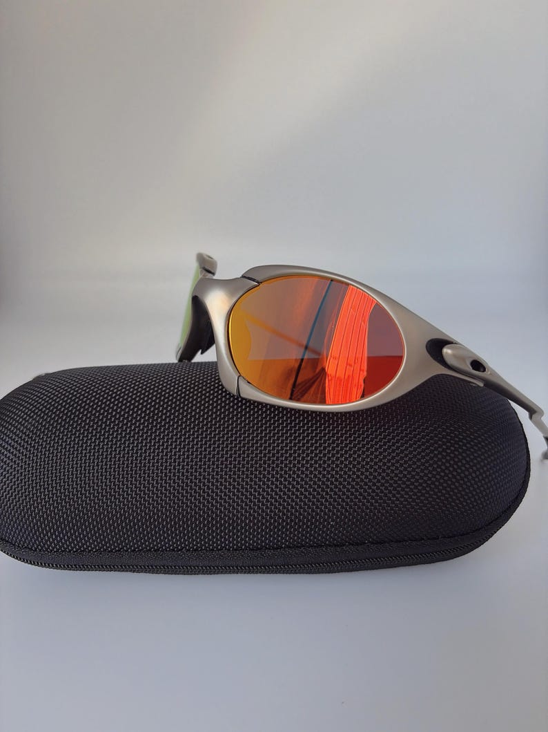 Gafas de sol retro Oakley Romeo X de metal con montura plateada mate y lentes polarizadas con degradado naranja, estilo vanguardista Y2K. imagen 3