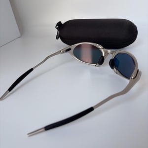 Gafas de sol retro Oakley Romeo X de metal con montura plateada mate y lentes polarizadas con degradado naranja, estilo vanguardista Y2K. imagen 5