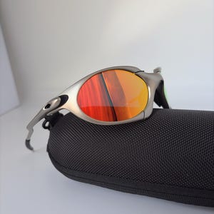 Gafas de sol retro Oakley Romeo X de metal con montura plateada mate y lentes polarizadas con degradado naranja, estilo vanguardista Y2K. imagen 4