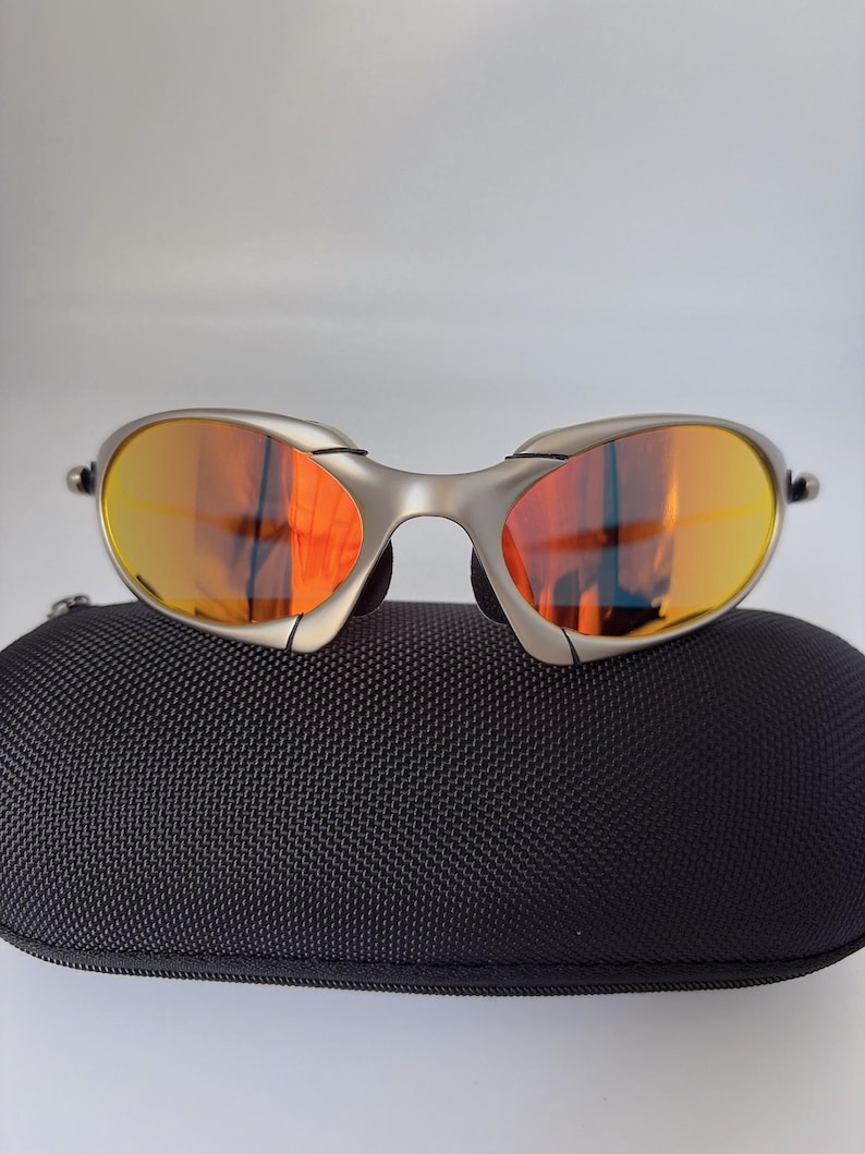Gafas de sol retro Oakley Romeo X de metal con montura plateada mate y lentes polarizadas con degradado naranja, estilo vanguardista Y2K. imagen 1