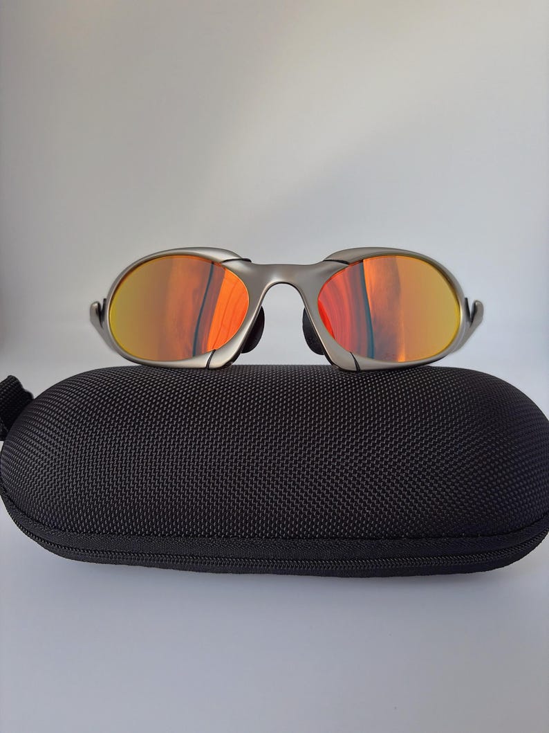 Gafas de sol retro Oakley Romeo X de metal con montura plateada mate y lentes polarizadas con degradado naranja, estilo vanguardista Y2K. imagen 2