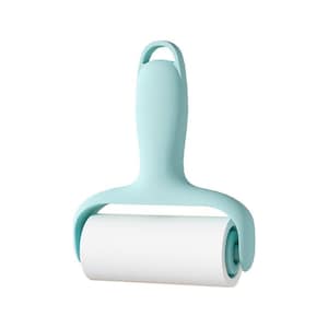 Puede incluir: Un rodillo quitapelusas de color azul claro con un mango ergonómico y liso que presenta una abertura circular en la parte superior para colgarlo. La hoja adhesiva cilíndrica es blanca y está sujeta por un marco azul claro unido al mango.