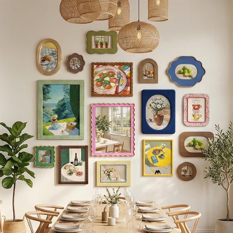 May include: A gallery wall featuring a collection of various framed art prints and a mirror. The frames include scalloped, rectangular, and oval shapes in colors like green, blue, pink, yellow, and wood tones. The art depicts food, landscapes, and still life.