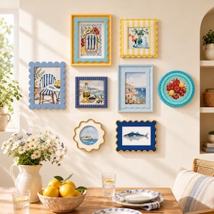 Puede incluir: Una pared de galería con ocho marcos decorativos de diversas formas y colores, incluyendo amarillo, azul y azul claro, que muestran láminas de arte de temática mediterránea con peces, limones, paisajes costeros y flores.
