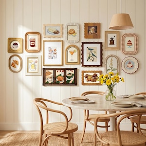 May include: A gallery wall featuring framed art with a breakfast theme. The artwork includes illustrations of pastries, coffee, and cocktails. The room also has a round marble table, wooden chairs, and a beige rug.