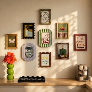 May include: A gallery wall arrangement featuring eight rectangular picture frames in various colors and textures, including beaded, scalloped, and smooth finishes. The frames display diverse illustrations, including a butterfly, a person, and coffee.