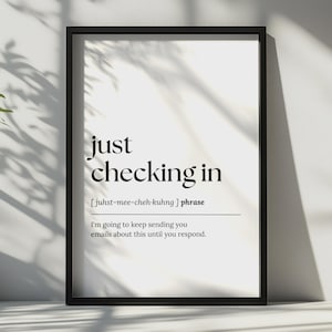 Könnte beinhalten: Ein schwarz gerahmter Wandkunstdruck mit dem Text just checking in, einer phonetischen Aussprachehilfe und der Definition: I'm going to keep sending you emails about this until you respond. Das Design zeigt schwarzen Text auf weißem Grund.