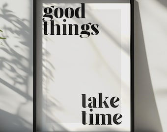 Puede incluir: Un marco rectangular negro que contiene una impresión blanca con el texto negro "good things" en la parte superior izquierda y "take time" en la parte inferior derecha. La tipografía es negrita y con serifa sobre un fondo claro.
