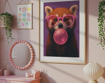 May include: A framed wall art print featuring a red panda with dark fur and white markings, wearing bright pink glasses and blowing a large, round, shiny pink bubblegum bubble against a solid purple background in a light wood frame.