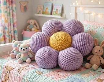 May include: A child's bedroom scene with a white bed, a floral quilt, and a large, handmade flower pillow in shades of purple and yellow. Stuffed animals, including a fox and a bunny, are arranged on the bed.