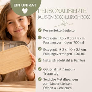 Peut inclure: Une bo&icirc;te &agrave; lunch personnalis&eacute;e avec un couvercle en bois clair et un int&eacute;rieur en acier inoxydable. Le texte sur l'image indique "PERSONALISIERTE JAUSENBOX / LUNCHBOX". La bo&icirc;te &agrave; lunch est en acier inoxydable et en bambou. La petite bo&icirc;te mesure 17,5 x 9,5 x 4,5 cm.