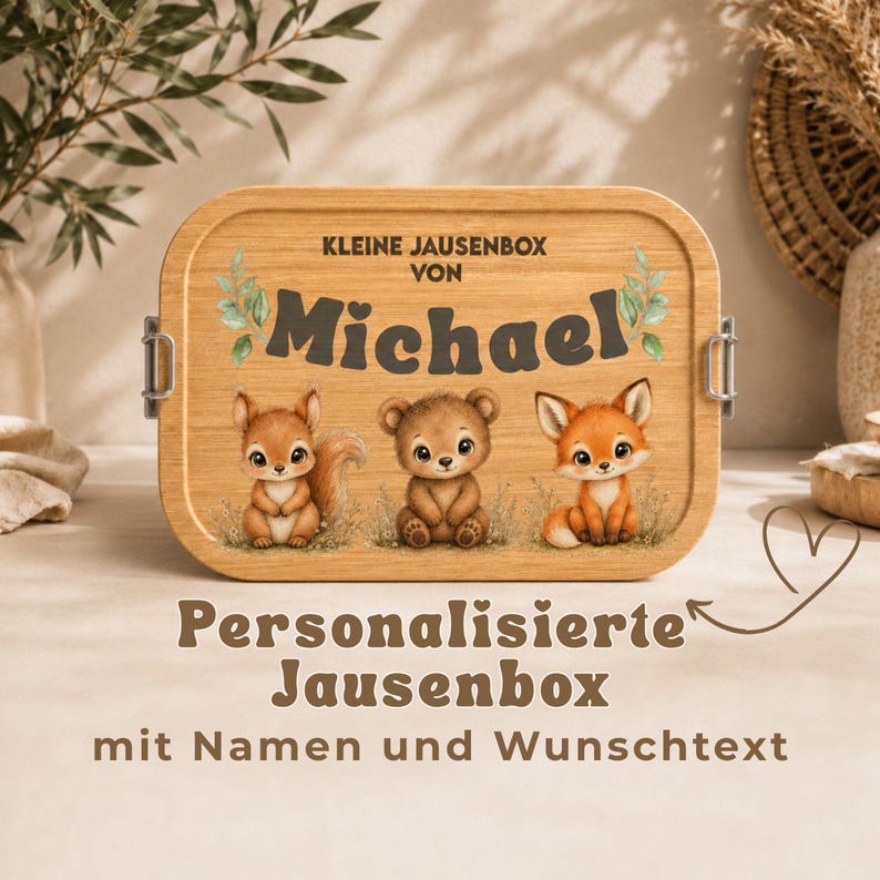 Peut inclure: Une bo&icirc;te &agrave; lunch en bois clair avec un design de trois animaux de dessin anim&eacute; : un &eacute;cureuil, un ours et un renard. Le nom "Michael" est affich&eacute;, avec le texte "KLEINE JAUSENBOX" et "Bo&icirc;te &agrave; lunch personnalis&eacute;e".