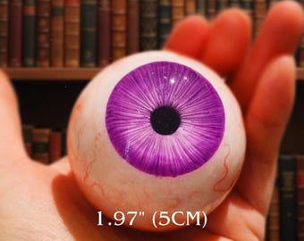 Olho de íris roxo realista: decoração de Halloween feita à mão, objeto gótico curioso.