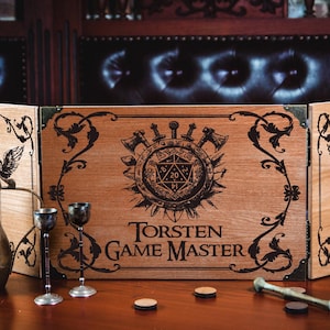 May include: A wooden game master screen with a decorative design and the text "Torsten Game Master". The screen is flanked by a brass pitcher, two goblets, and other game accessories. The screen has a central emblem with axes, swords, and a 20-sided die.