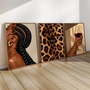 May include: A set of three framed wall art prints. The first shows a profile of a person with braided hair and gold hoop earrings. The second features a leopard print pattern with the text HER. The third depicts a hand holding a wine glass.
