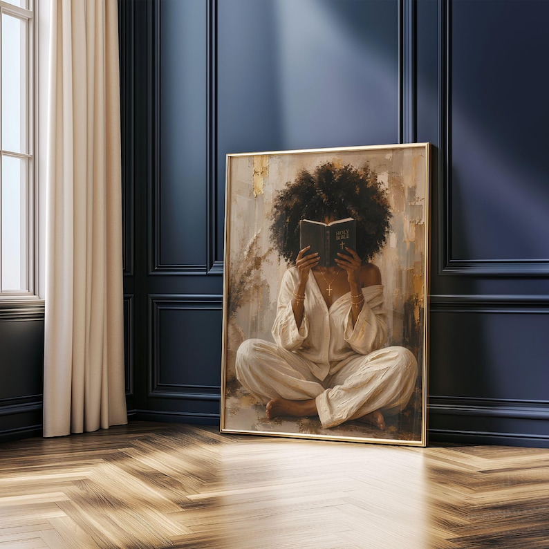Pu&ograve; includere: Una stampa artistica incorniciata raffigurante una persona con voluminosi capelli ricci scuri seduta a gambe incrociate in un completo lounge color crema, che tiene un libro aperto davanti al viso. Lo sfondo presenta pennellate dorate e beige.