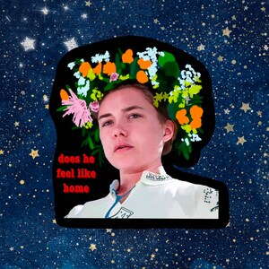 May include: A sticker featuring a person with a floral crown and the text "does he feel like home" in red. The background is a starry night sky with gold stars.