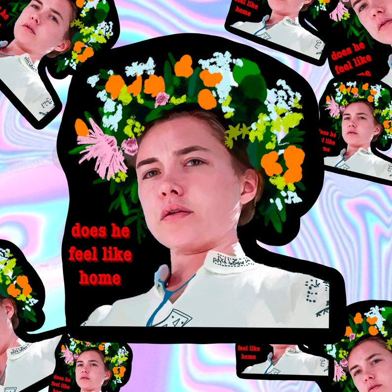 May include: A digital art print featuring a woman with a floral crown and the text "does he feel like home" in red. The image has a black border and is set against a colorful, iridescent background. The woman is wearing a white top.