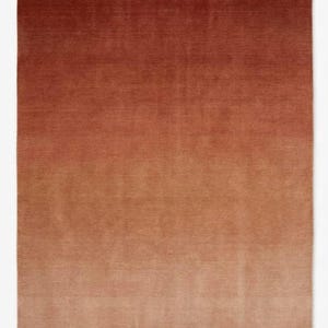 Pode incluir: Um tapete retangular com um gradiente de cor. O tapete transita de um castanho avermelhado escuro no topo para um castanho claro, bege na parte inferior. A textura parece macia e felpuda, adequada para um espaço habitável.
