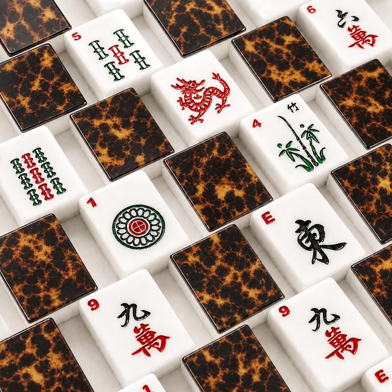 May include: A collection of Mahjong tiles arranged in a grid pattern. The tiles feature white faces with various red, green, and black symbols, numbers, and characters, alternating with dark brown and black tortoiseshell patterned backs.
