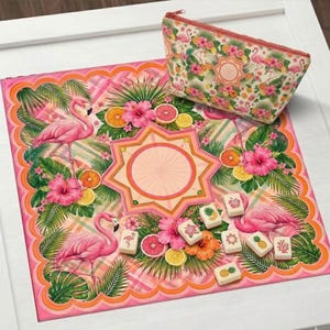May include: A pink flamingo-themed set featuring a decorative mat and a zippered pouch. The mat showcases flamingos, tropical flowers, and fruit. The pouch and mat have a matching design. Small decorative tiles are also present.