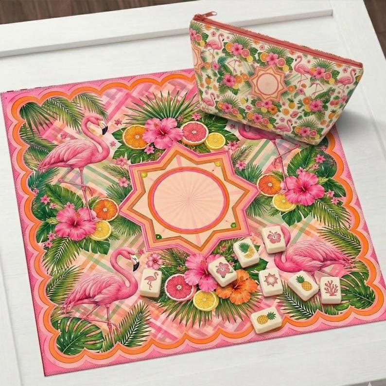 May include: A pink flamingo-themed set featuring a decorative mat and a zippered pouch. The mat showcases flamingos, tropical flowers, and fruit. The pouch and mat have a matching design. Small decorative tiles are also present.