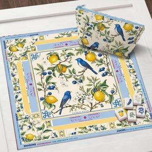 Puede incluir: Un conjunto decorativo con un dise&ntilde;o de limones, ar&aacute;ndanos y p&aacute;jaros azules. Incluye una bolsa con cremallera, una alfombra cuadrada y fichas de juego. El conjunto tiene una combinaci&oacute;n de colores azul claro y amarillo.