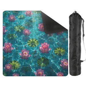 May include: A yoga mat featuring a serene water scene with pink lotus flowers and green lily pads. The mat has a black underside and is accompanied by a black carrying bag with a shoulder strap. The mat's design evokes a sense of tranquility.