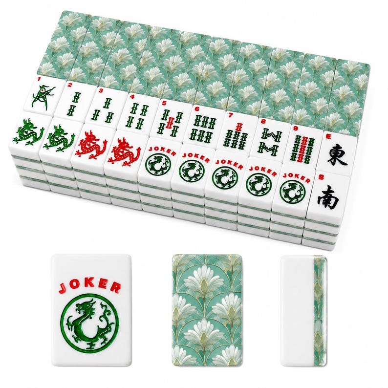 May include: A complete Mahjong set with white tiles featuring red and green symbols and characters. The tiles are stacked, with a decorative floral pattern on the back. One tile reads "JOKER" with a green dragon.
