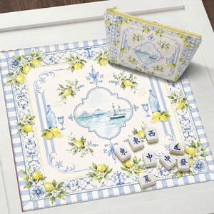 Peut inclure: Un ensemble d&eacute;coratif sur le th&egrave;me des citrons. Il comprend un tapis rectangulaire avec une bordure &agrave; rayures bleues et blanches, une pochette zipp&eacute;e assortie et des tuiles de Mahjong. Le tapis et la pochette pr&eacute;sentent une illustration &agrave; l'aquarelle d'un paysage marin.