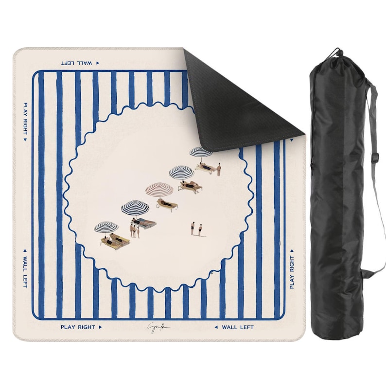 May include: A beach mat with a whimsical illustration of a beach scene, featuring blue and white striped borders and a central design of beach umbrellas and sunbathers. Includes a black carrying bag with a shoulder strap.